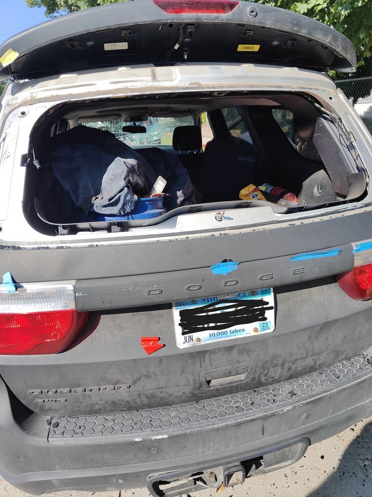 A car with a broken windshield is parked on the side of the road.