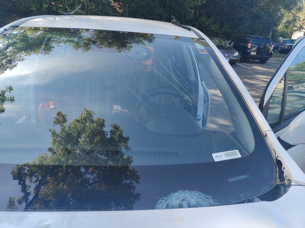 A white car is parked on the side of the road