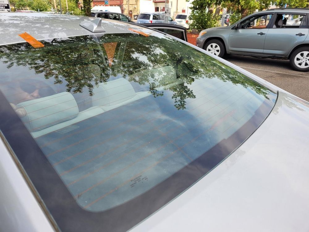 A close up of a car windshield with a parking ticket on it