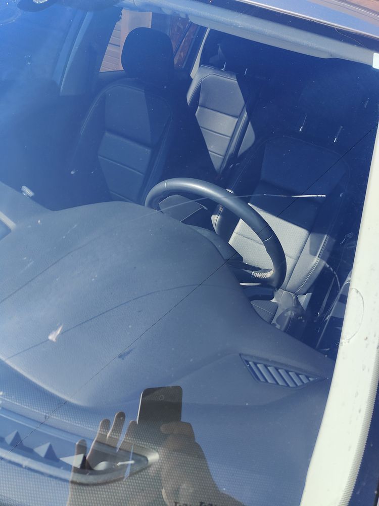 A steering wheel is visible through the windshield of a car