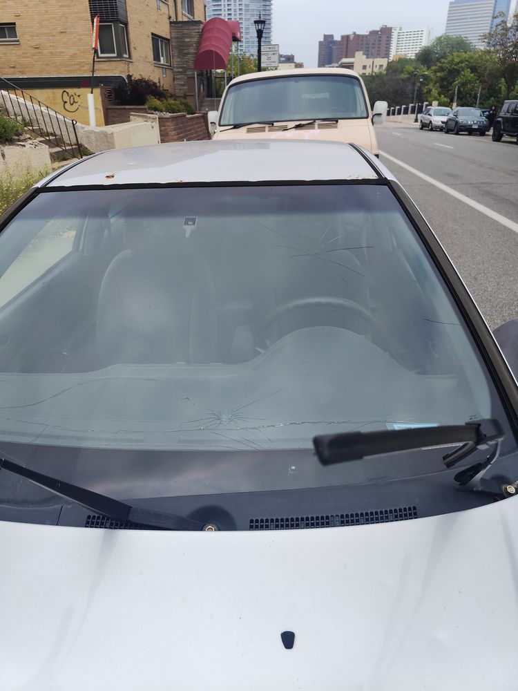A silver car is parked on the side of the road