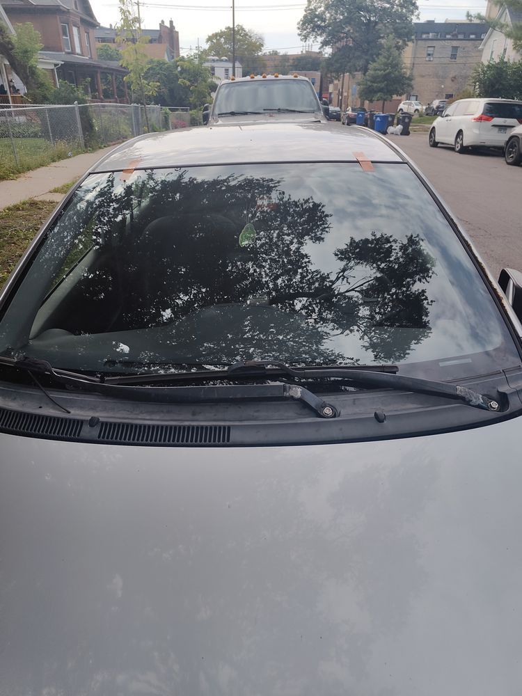 A silver car is parked on the side of the road.