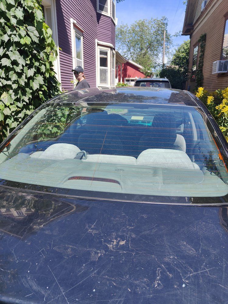 A black car is parked in front of a purple house.