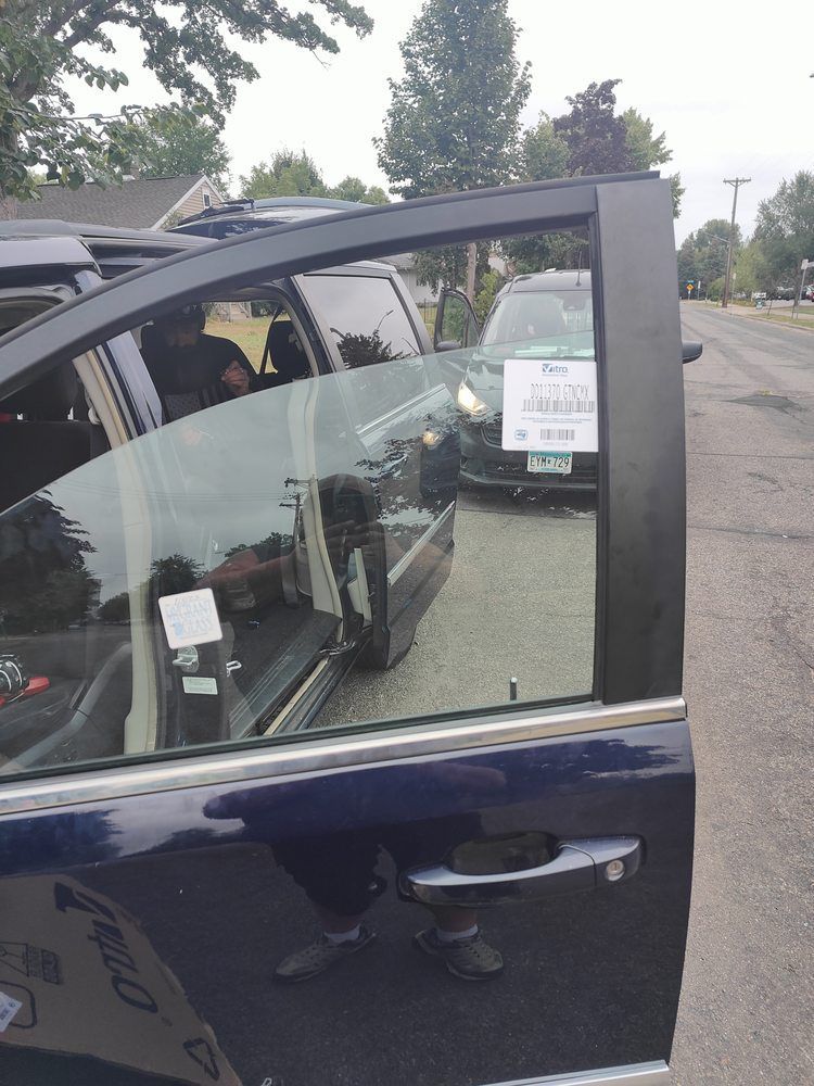 A blue car with a sign on the door that says keep driving