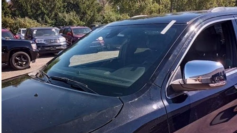 A black suv is parked in a lot with other cars.