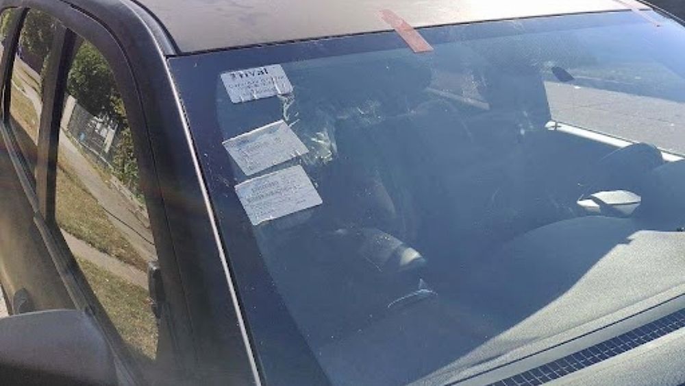 A close up of a car windshield with a tag on it.