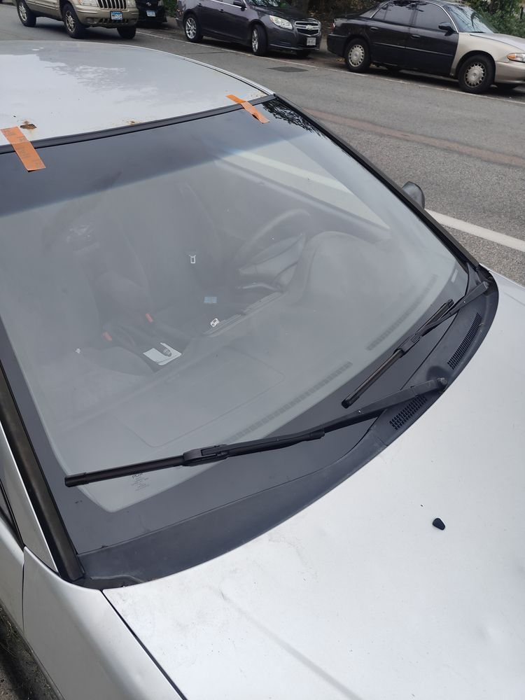 A silver car is parked on the side of the road