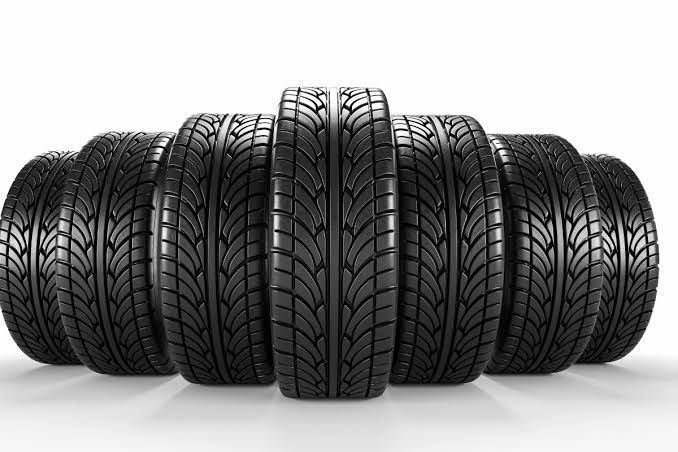 Um grupo de pneus empilhados uns sobre os outros em uma superfície branca.