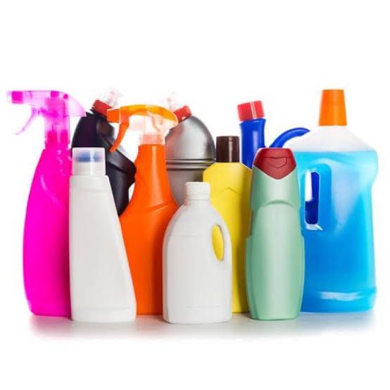 Um grupo de materiais de limpeza está alinhado em uma fileira sobre um fundo branco.