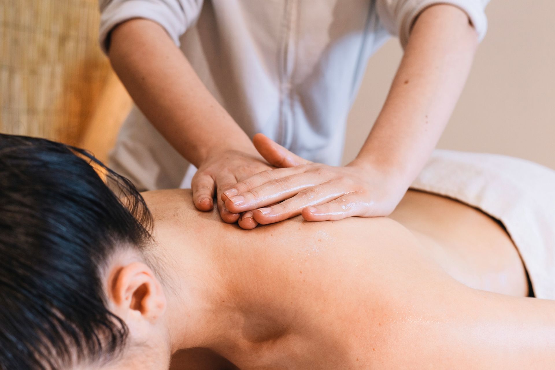A woman is getting a massage on her back at a spa.