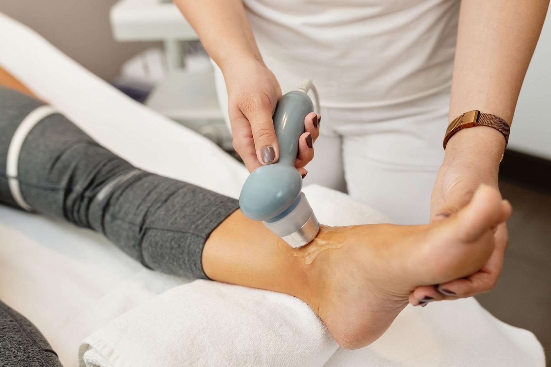 A woman is getting a massage on her ankle in a spa.