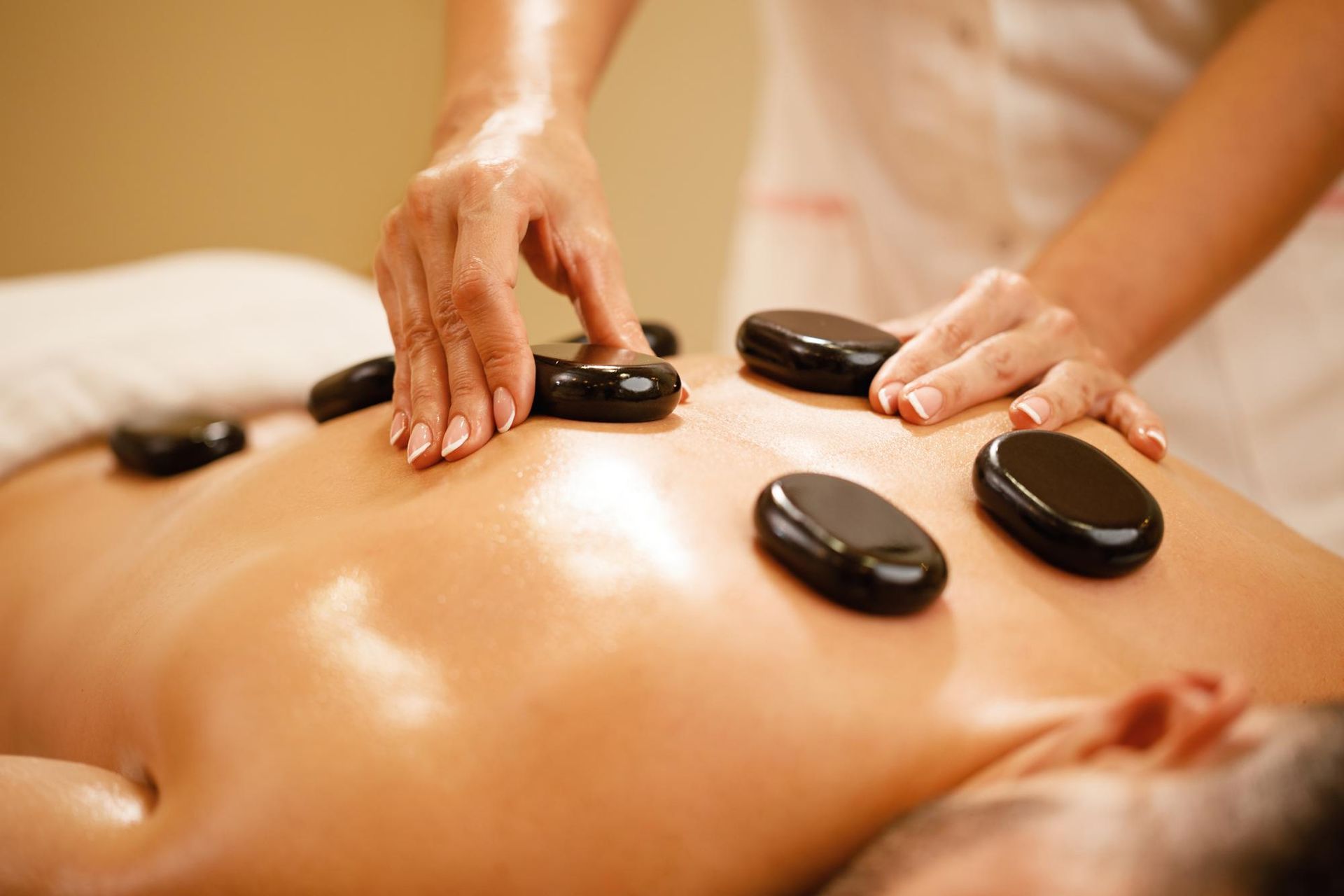 A woman is getting a hot stone massage at a spa.