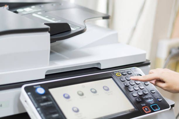 A Person Is Pressing a Button on A Printer - Jasper, IN - Impressions Printing Inc