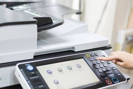 A Person Is Pressing a Button on A Printer - Jasper, IN - Impressions Printing Inc