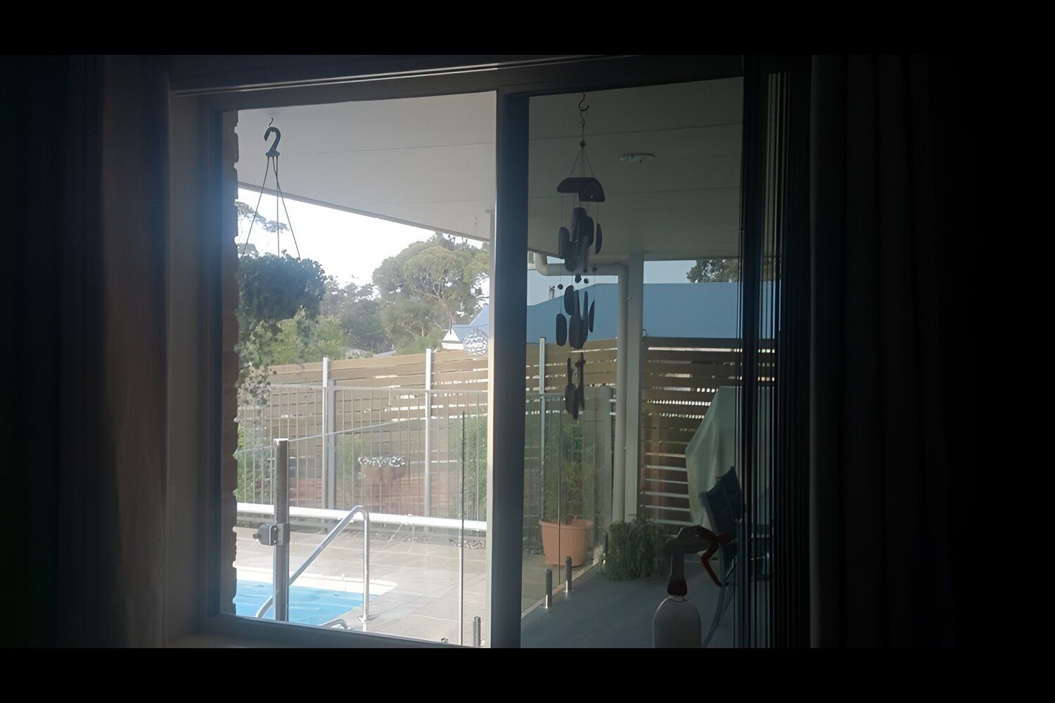 A Room With A Sliding Glass Door Leading To A Pool — Solartint South Coast (Juz Tint) In Braidwood, NSW