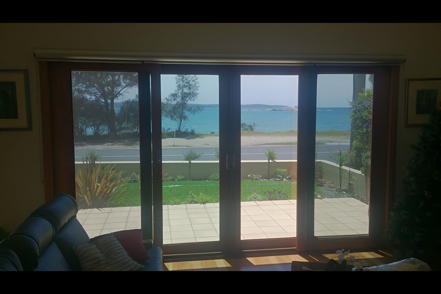 A Living Room With A View Of The Ocean Through The Sliding Glass Doors — Solartint South Coast (Juz Tint) In Braidwood, NSW