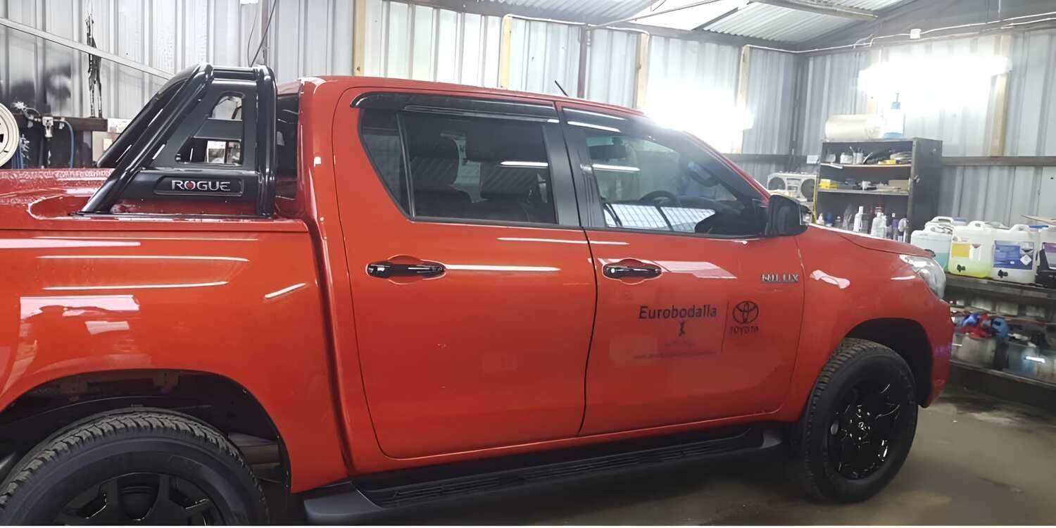 A Red Truck And A White Truck Are Parked In A Garage — Solartint South Coast (Juz Tint) In Batemans Bay, NSW