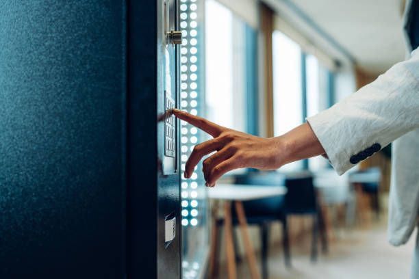 A person is pressing a button on a vending machine.
