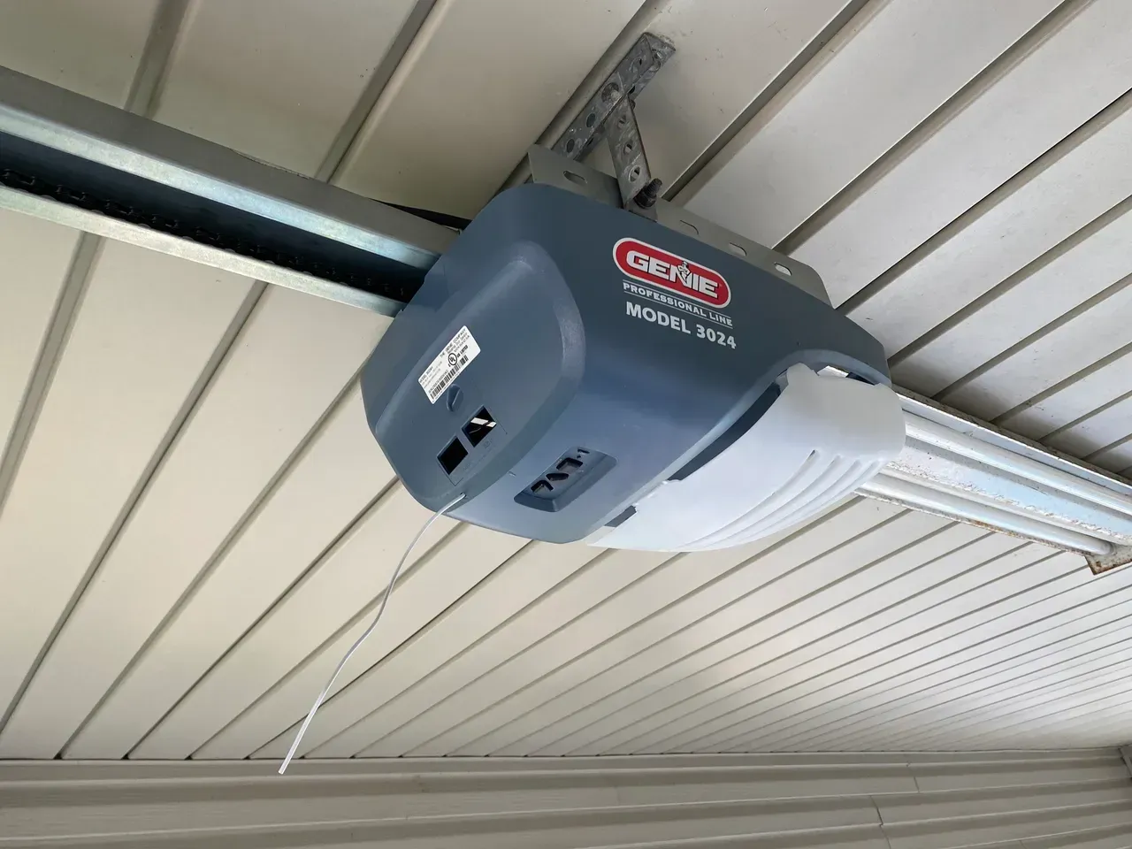 Genie garage door opener, model 4024, mounted on a white paneled ceiling.