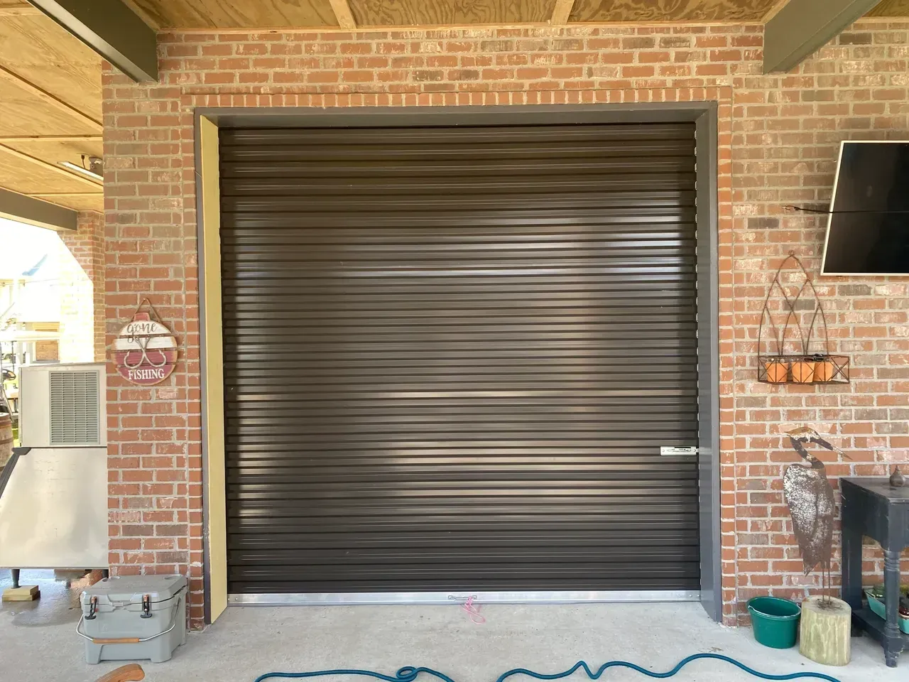 Brown roll-up garage door in a brick building.