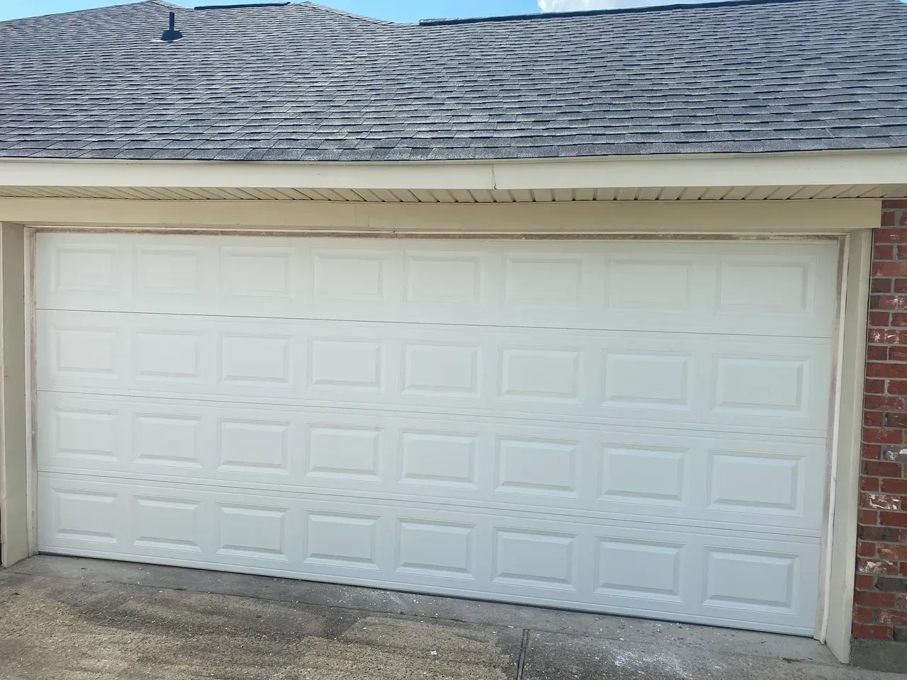 White panel garage door with a textured roof above.