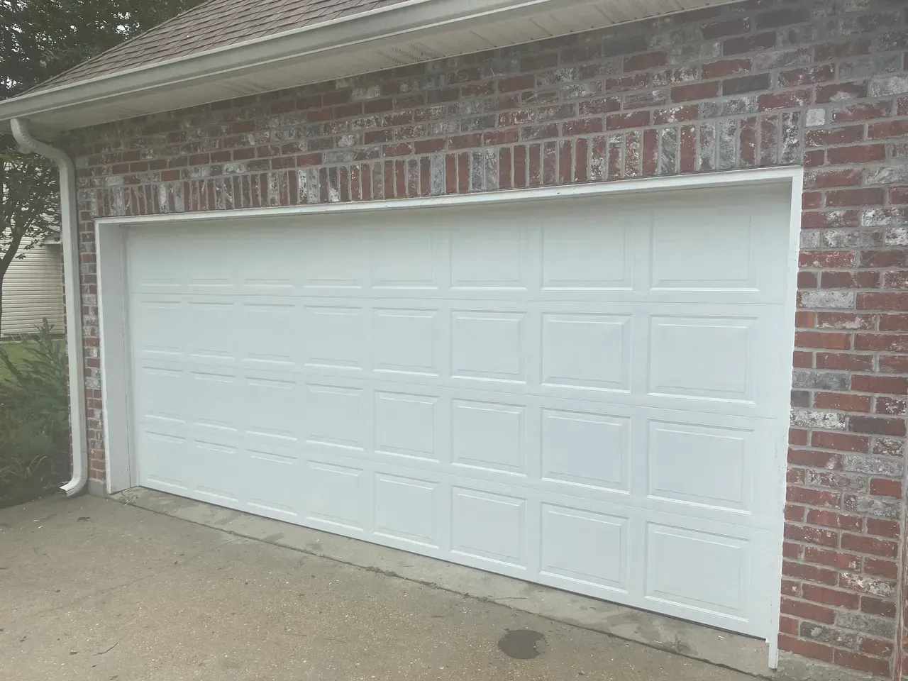 White garage door on brick building.