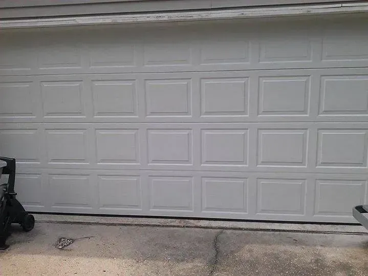 White garage door with rectangular panel design. Concrete driveway below.