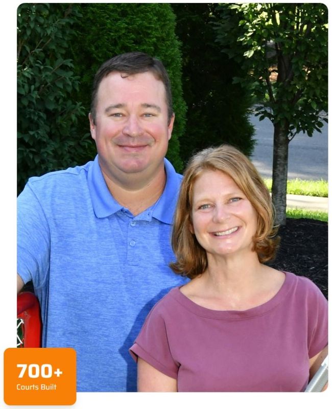 A smiling man in a blue polo and a woman in a purple shirt standing outdoors with a '700+ Courts Built' icon.