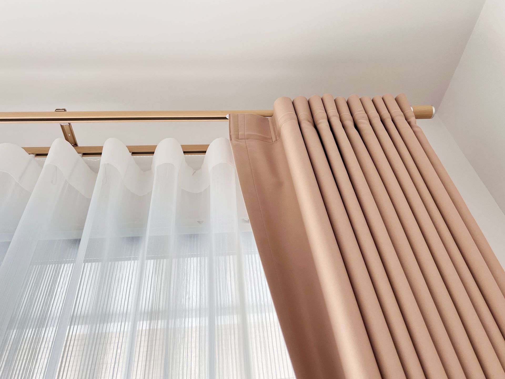 A close up of a pair of curtains hanging on a window.