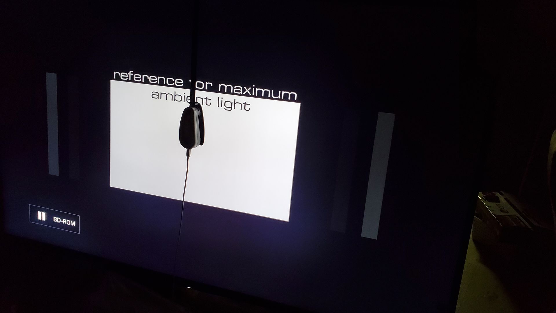 A tv screen shows a picture of a person standing in the dark.