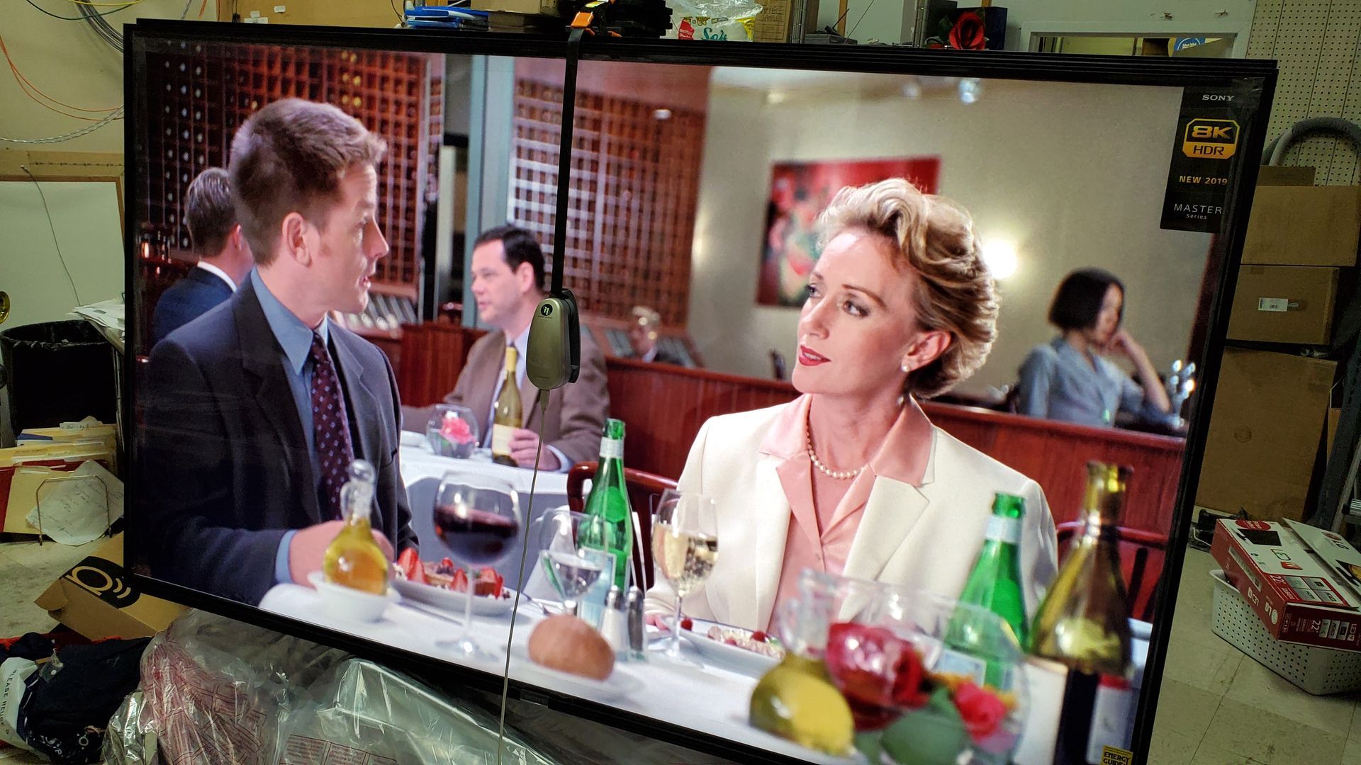 A man and a woman are sitting at a table with bottles of wine