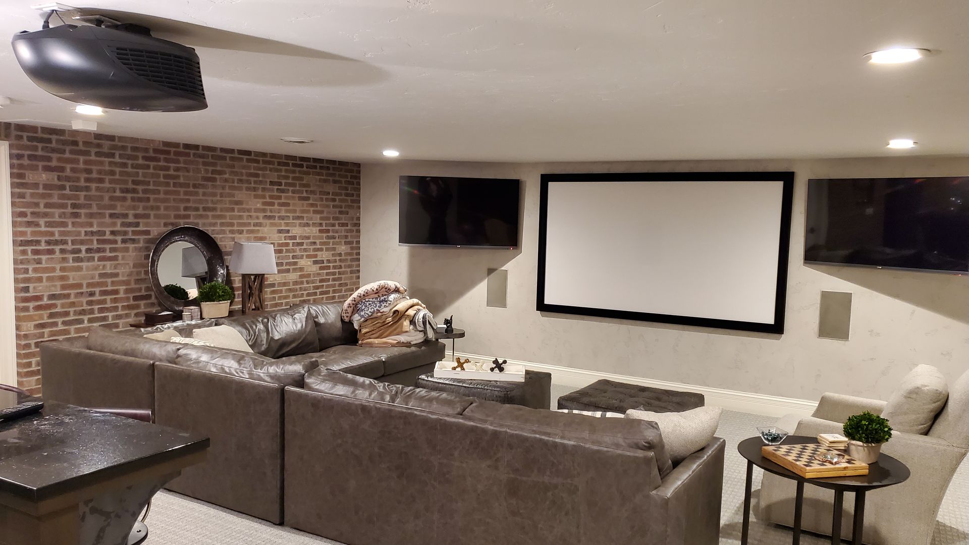 A living room with a couch and a projector screen.