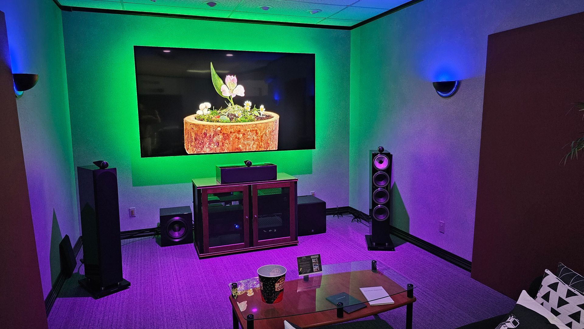 A living room filled with furniture and a large screen.