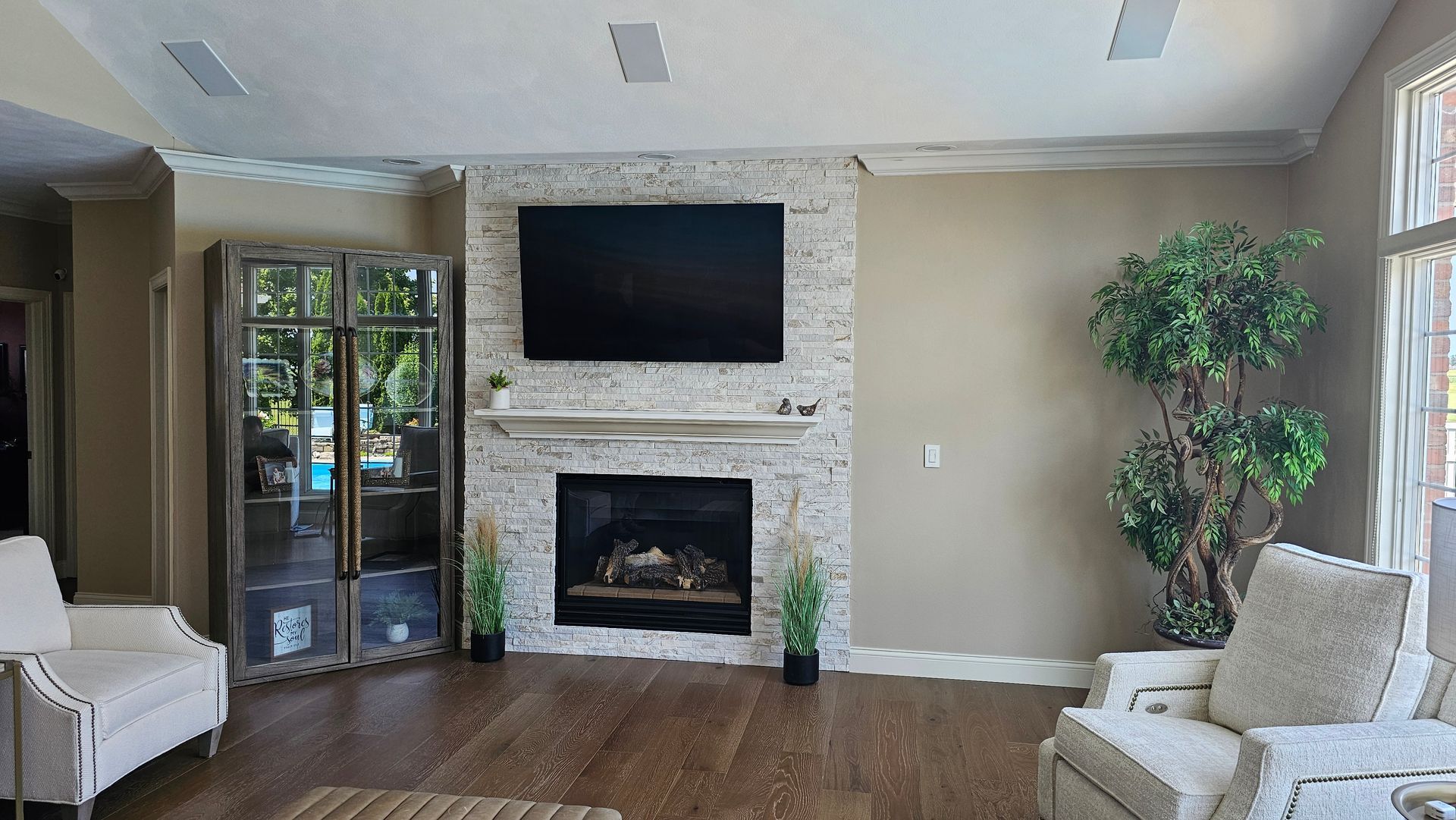 A living room with a fireplace and a flat screen tv on the wall.