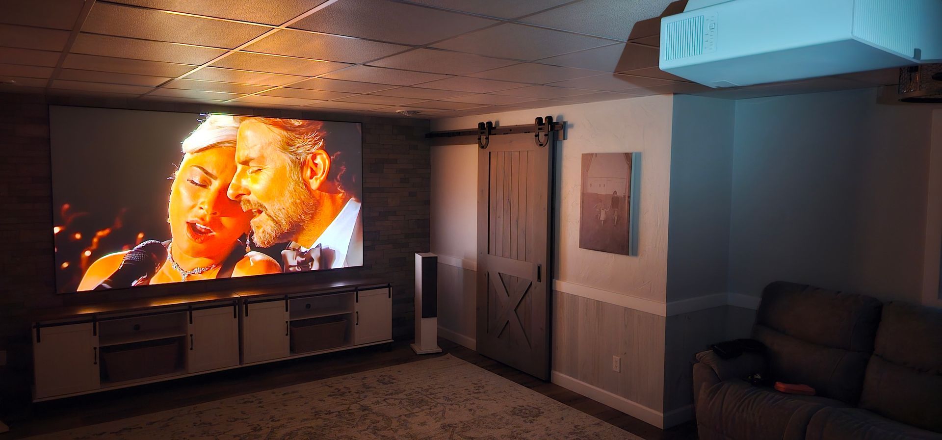 A living room with a projector screen and a couch.