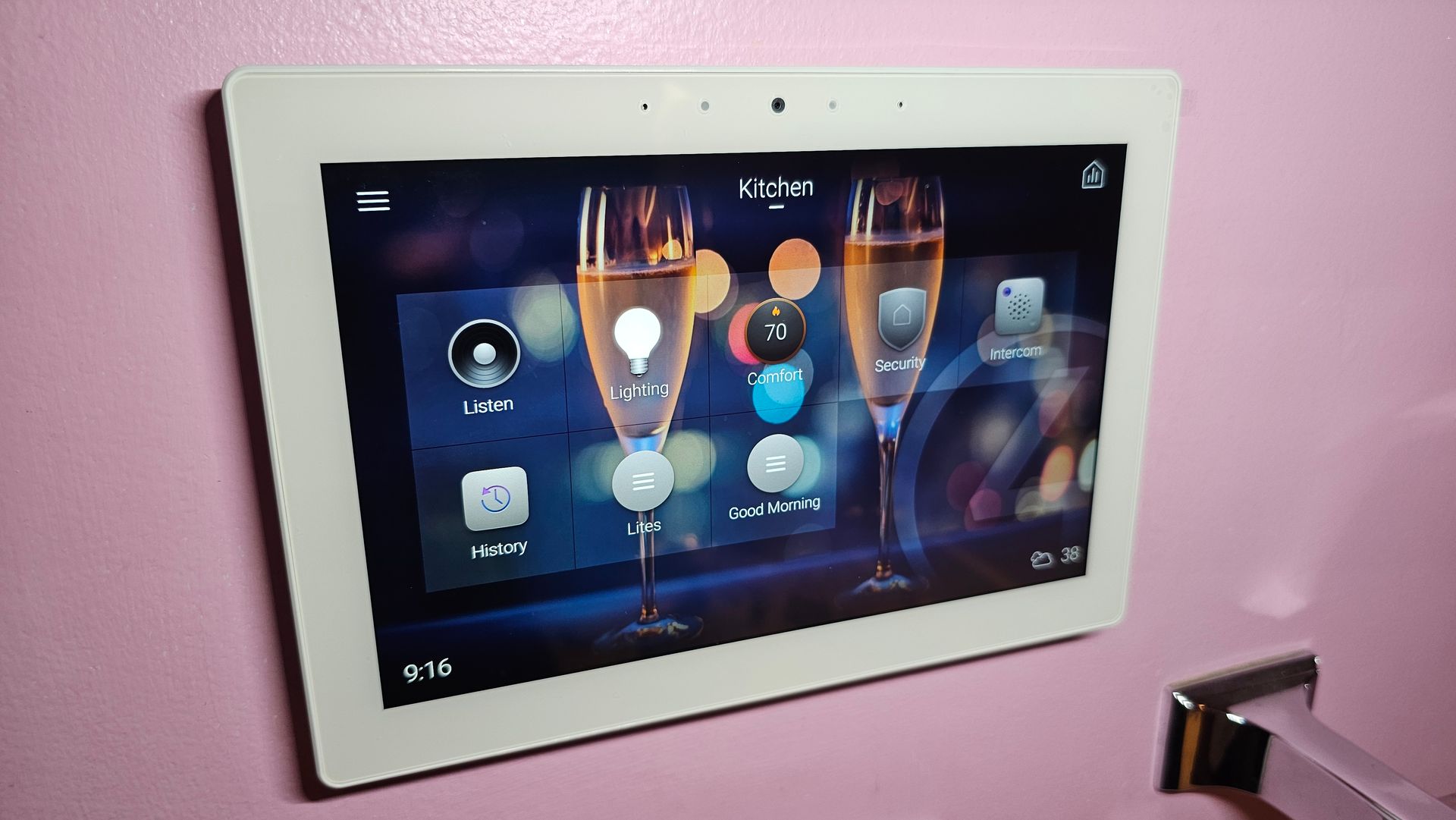 A white tablet is hanging on a pink wall.