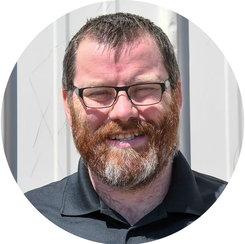 A man with a beard and glasses is smiling in a circle.