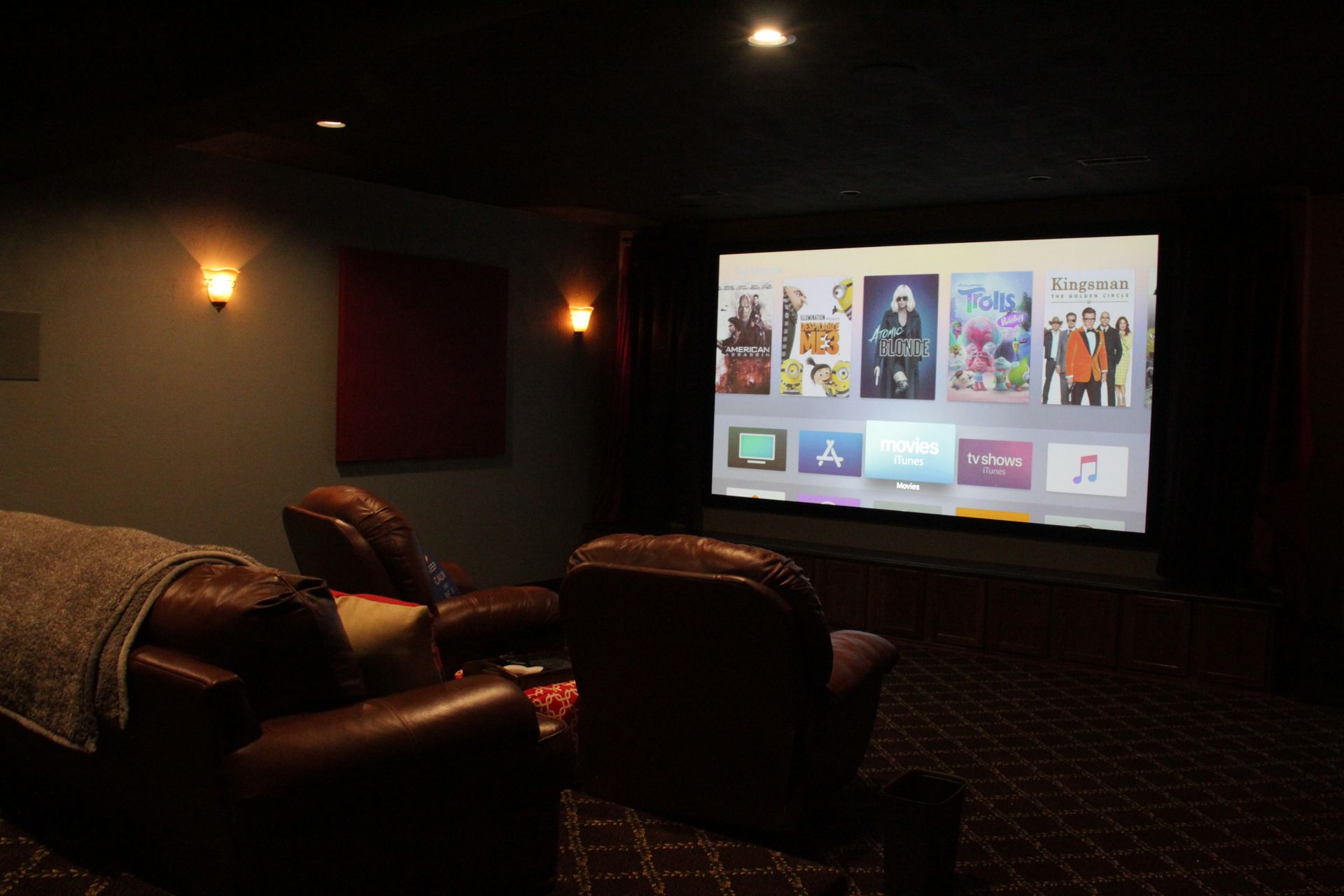 A home theater with two chairs and a large screen