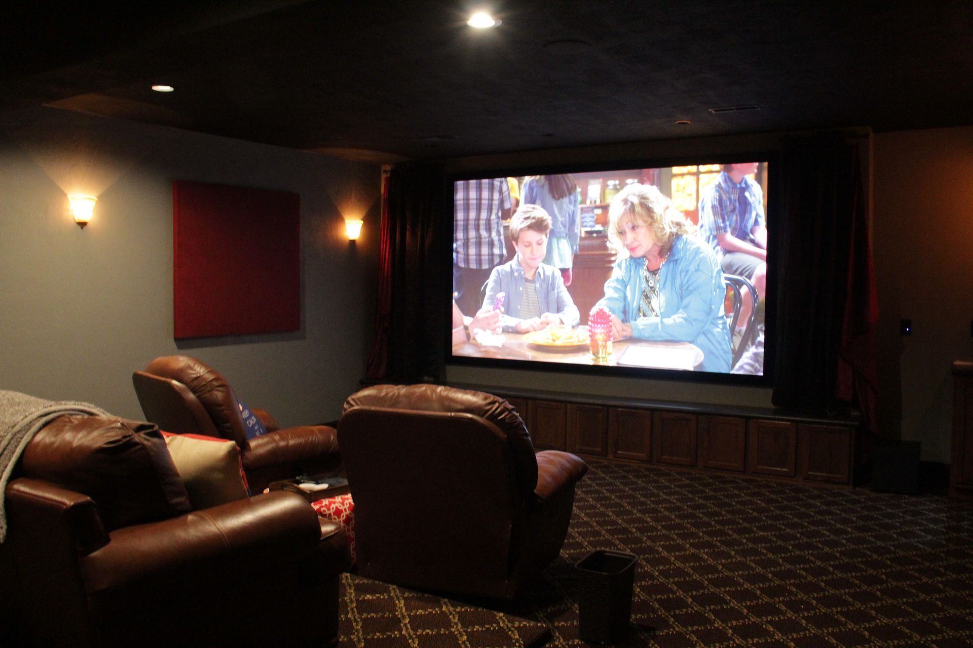 A home theater with two chairs and a large screen.