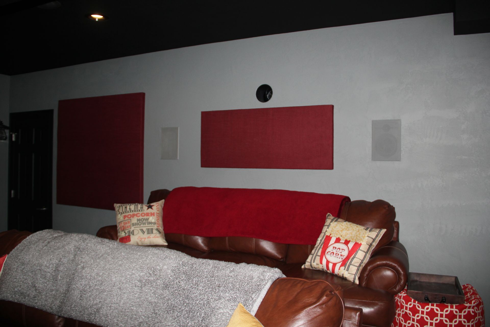 A living room with a brown couch and a red blanket