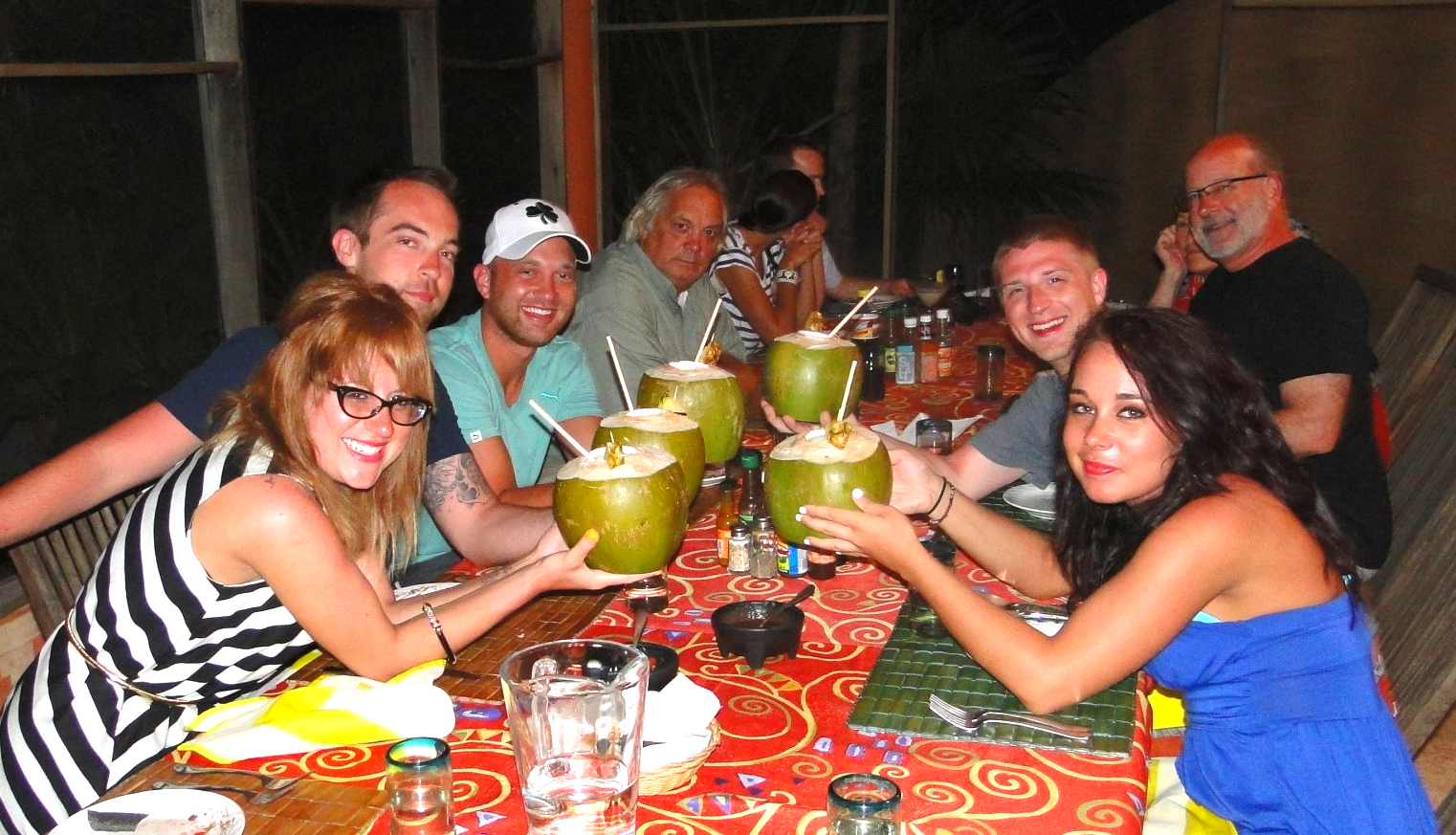 Pina colada in a coconut gathered around the long table