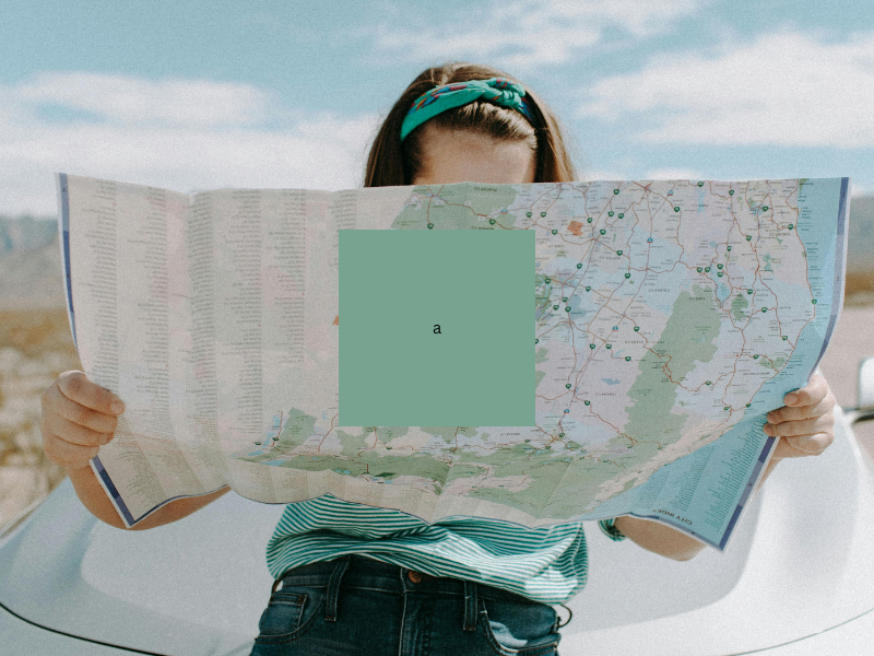 A woman is holding a map in front of her face.