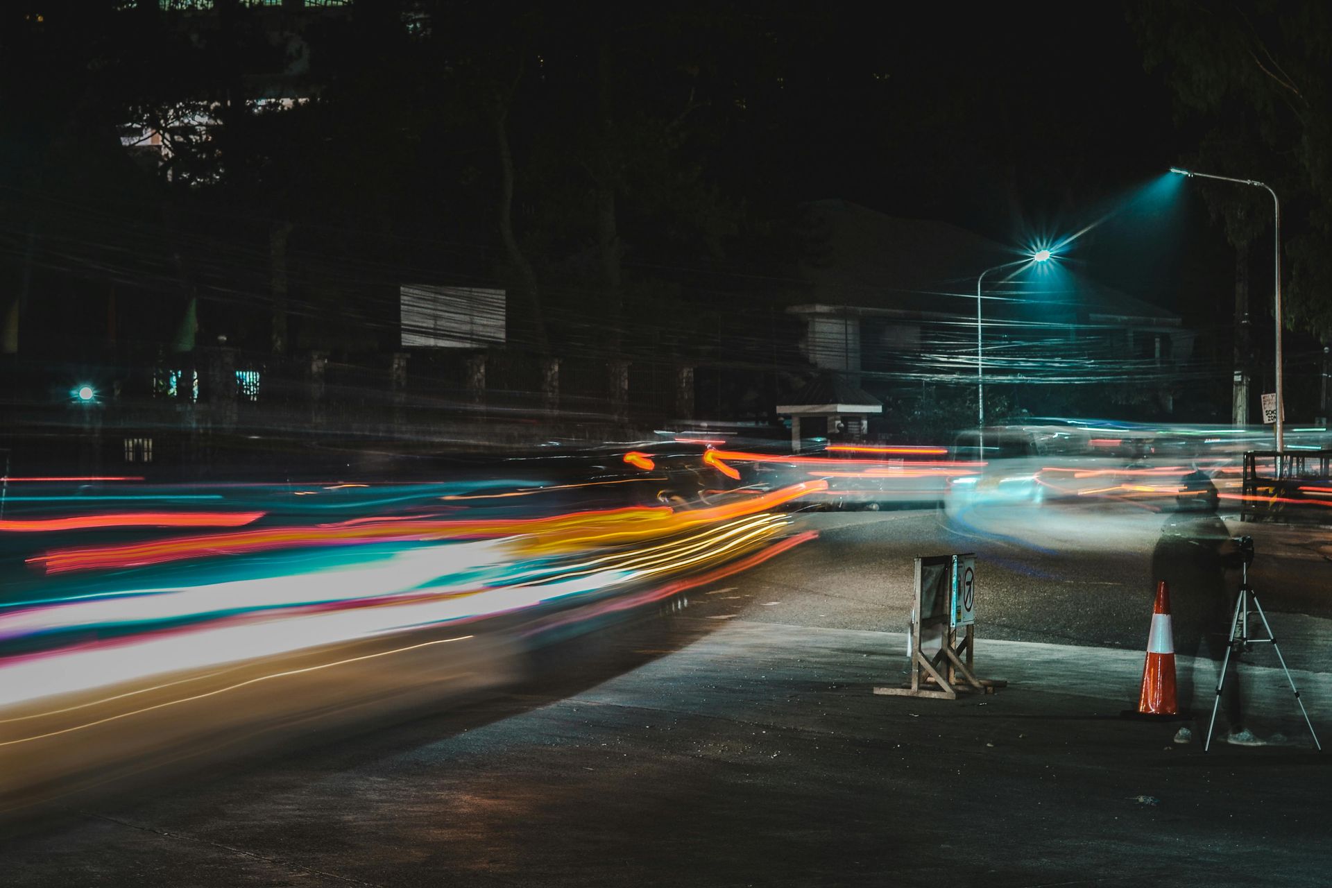 A blurry picture of a street at night with cars driving down it.