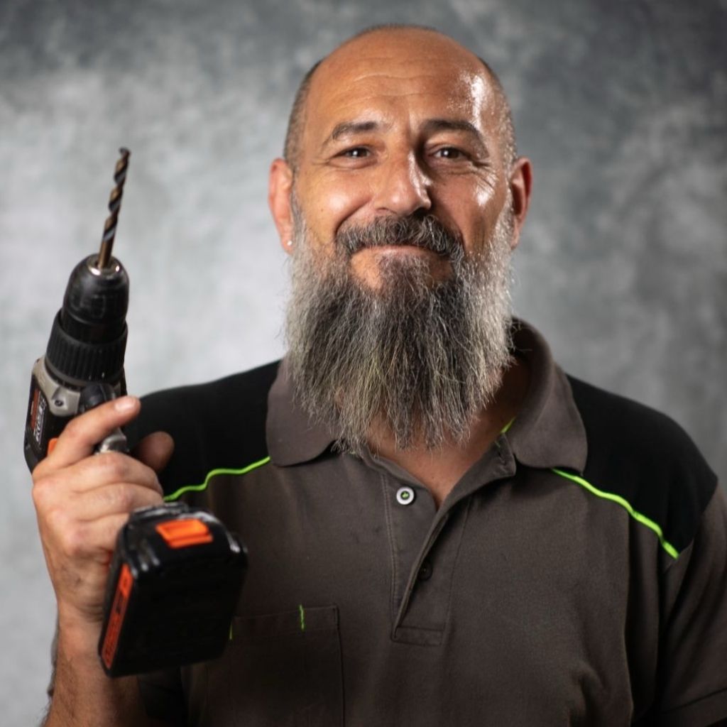 Woman in a black blazer and glasses smiles, wearing a name tag.