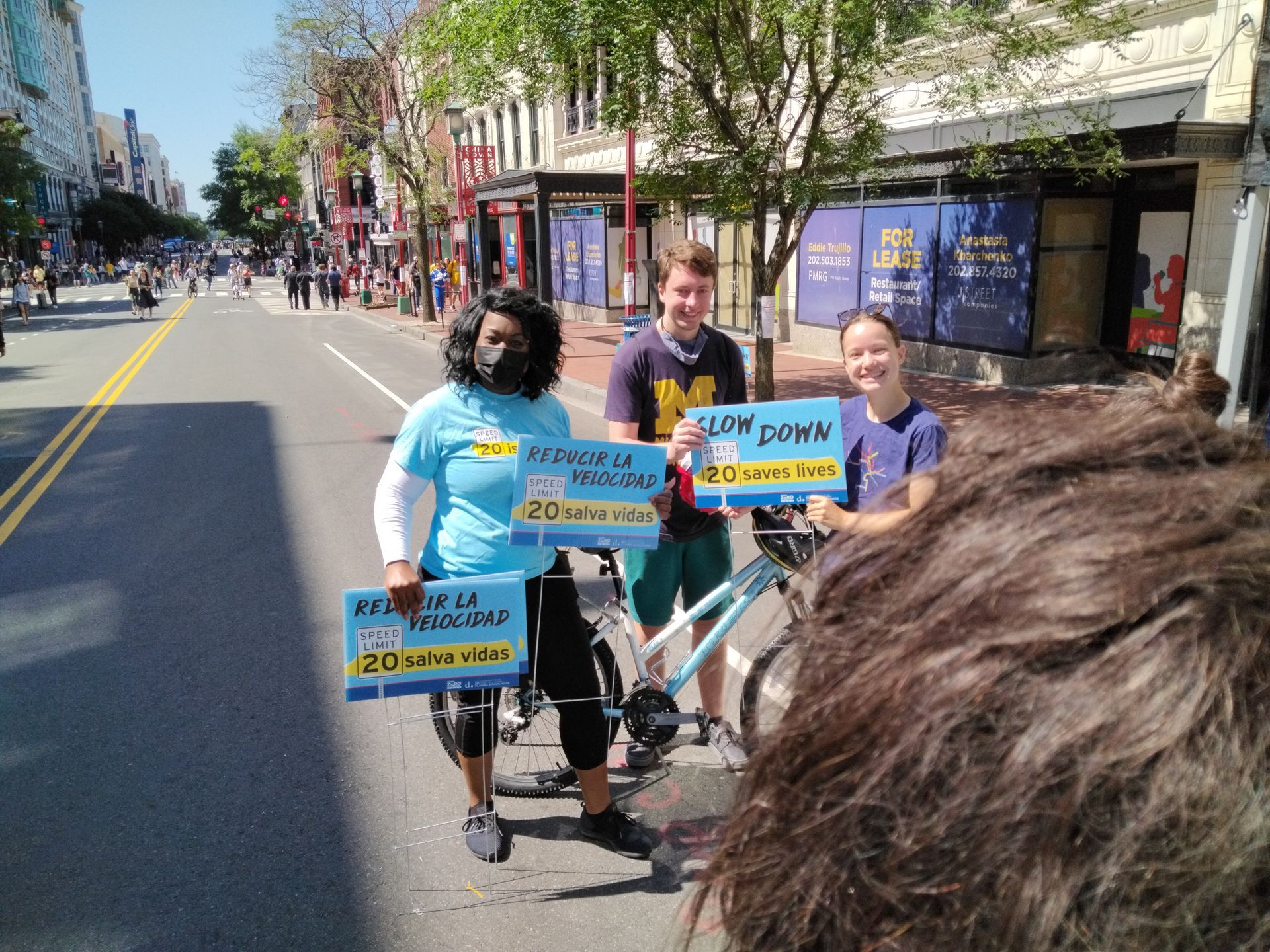 A group of people holding signs on the side of a street including one that says i love oma