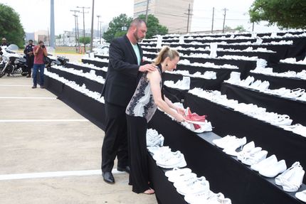 A man and a woman are looking at a display of white shoes