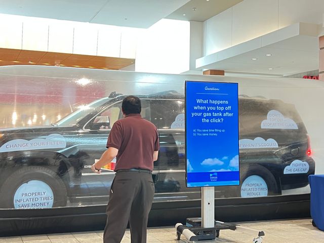 A man stands in front of a screen that says ' when ' on it