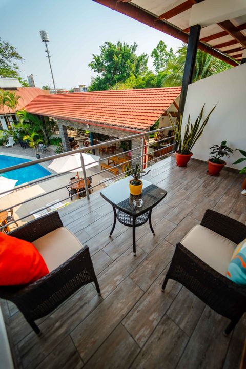 Toallas enrolladas con flores sobre una cama en una habitación de hotel.