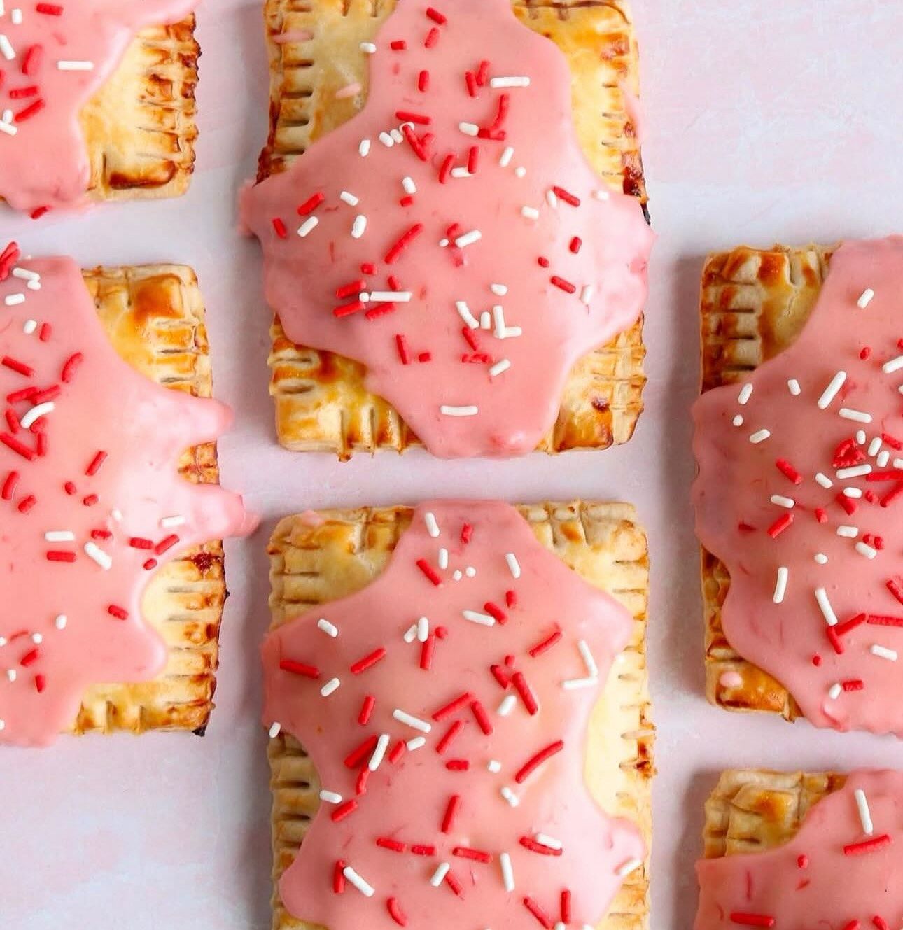 A bunch of toaster pastries with pink frosting and sprinkles