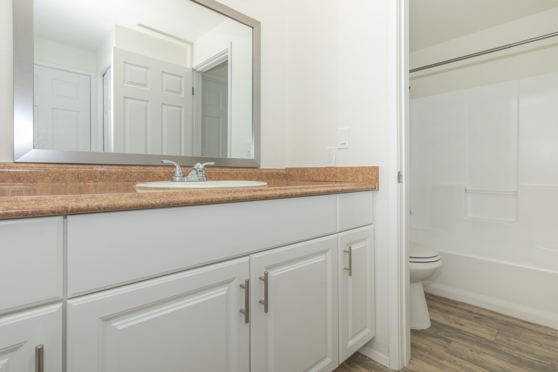 A bathroom with a sink , mirror , toilet and bathtub.